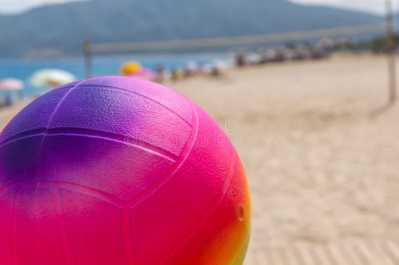 Beach Volleyball Ball in the Foreground on the Sand Beach Stock Photo