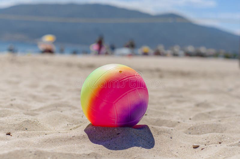 Beach Volleyball Ball in the Foreground on the Sand Beach Stock Photo