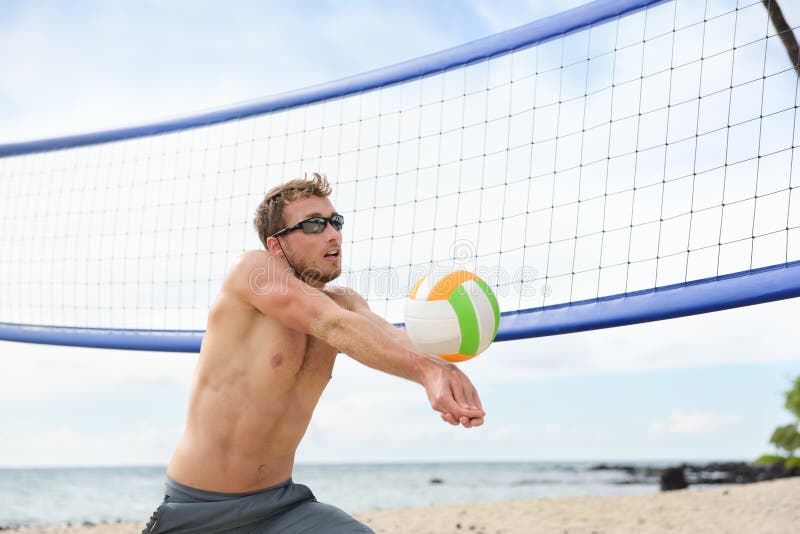 Beach volleyball man playing game hitting forearm pass volley ball during match on summer beach. Male model living healthy active lifestyle doing sport on beach. Beach volleyball man playing game hitting forearm pass volley ball during match on summer beach. Male model living healthy active lifestyle doing sport on beach.