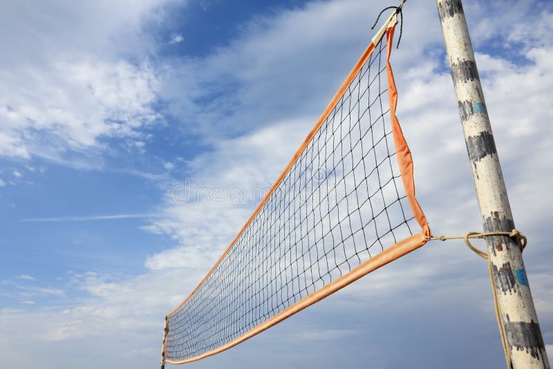A beach volleyball net in sunny day over blue cloudy sky