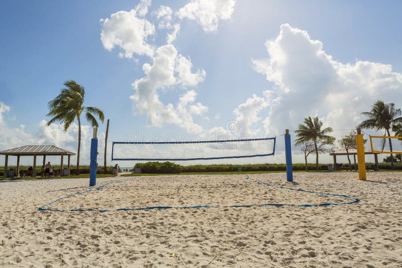 A Beach Volleyball Net on a Sunny Beach, with Palm Trees Stock Photo