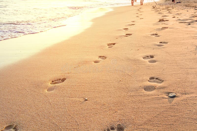 Beach, wave and footsteps in Greece, yellow sun