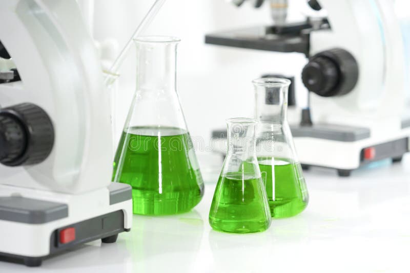 Beaker of Green Chemical on Table with Blurred Microscope Stock Image Image of liquid, biology