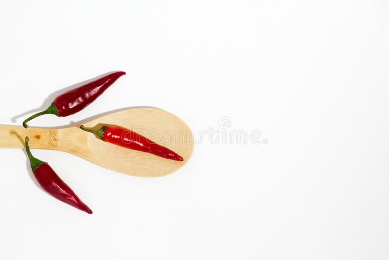 Beam of red chilli pepper and wooden spoon on white background . stock images Beam of red chilli pepper and wooden spoon on white background . stock images