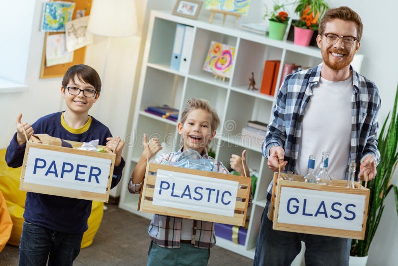 Beaming bearded teacher standing with his little students royalty free stock image