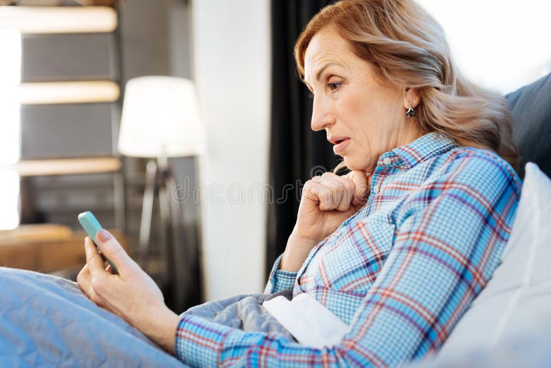 Beaming good-looking adult woman resting in bed in the morning stock image Beaming good-looking adult woman resting in bed in the morning stock image