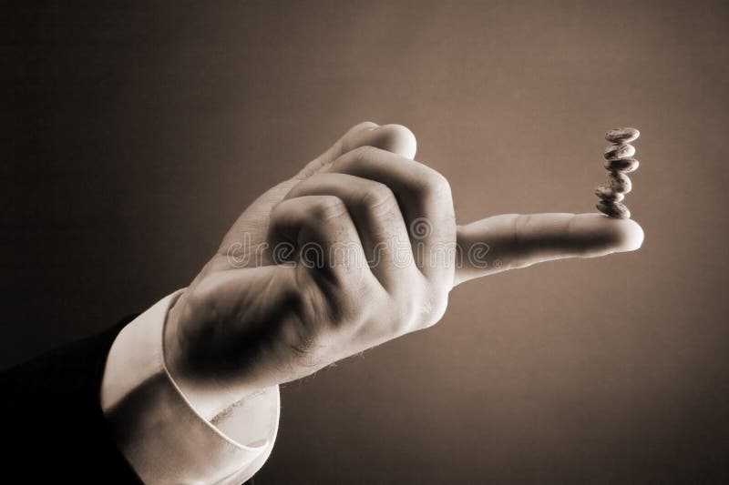Bean Counter. Accounting Concept: Bean Counter: Stack of brown beans balancing on tip of finger Bean Counter. Accounting Concept: Bean Counter: Stack of brown beans balancing on tip of finger
