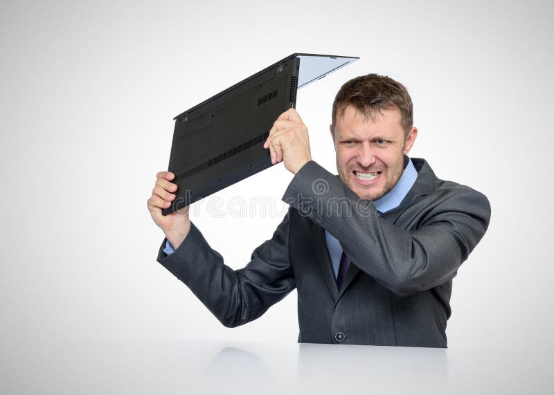 Bearded Businessman smashing his laptop stock image Bearded Businessman smashing his laptop stock image