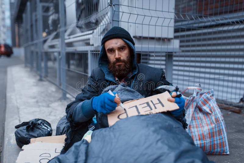 Bearded dirty homeless writes help sign