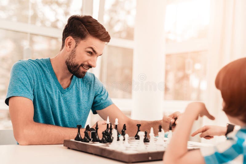 Папа играет в шахматы. Папа с сыном играют в шахматы. Картинка где сын с отцом играют в шахматы на столе. Отец и сын играют в шахматы на полу. Modern Hobbies.