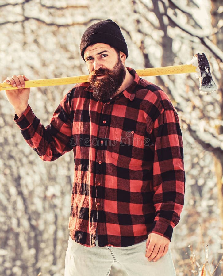 Bearded lumberjack. Brutal bearded lumberjack with ax in winter forest. Handsome man, hipster in snowy forest