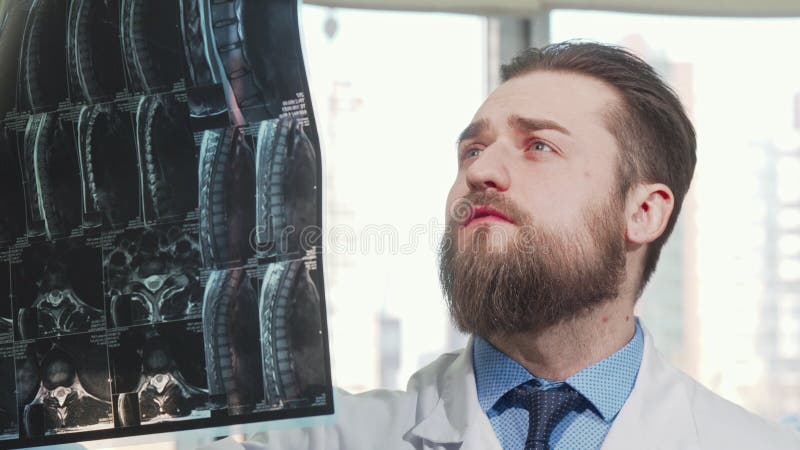 Bearded male doctor examining mri scan of his patient stock photo Bearded male doctor examining mri scan of his patient stock photo