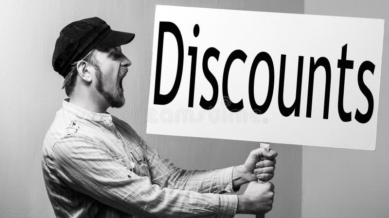 Bearded male worker in a cap shouts with a poster in his hands. Inscription discounts. Shopping concept stock photos Bearded male worker in a cap shouts with a poster in his hands. Inscription discounts. Shopping concept stock photos