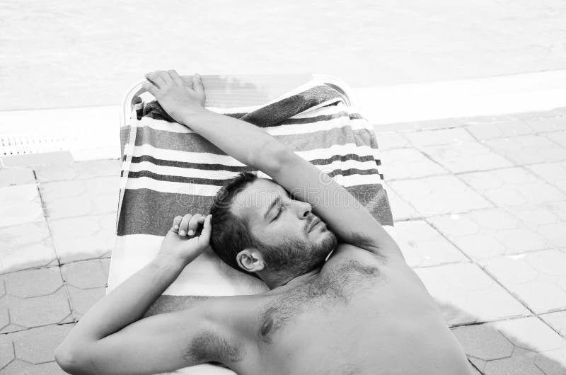 Handsome tanned bearded man relaxing on the beach. Handsome tanned bearded man relaxing on the beach