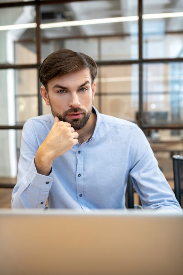 Bearded man in a blue shirt thinking about new project royalty free stock photo Bearded man in a blue shirt thinking about new project royalty free stock photo