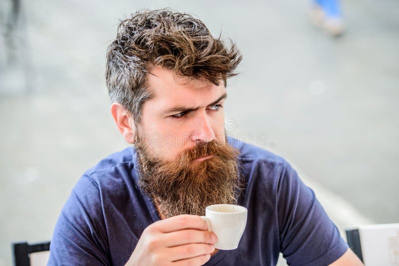 Mature bearded hipster man drinking coffee while working overtime