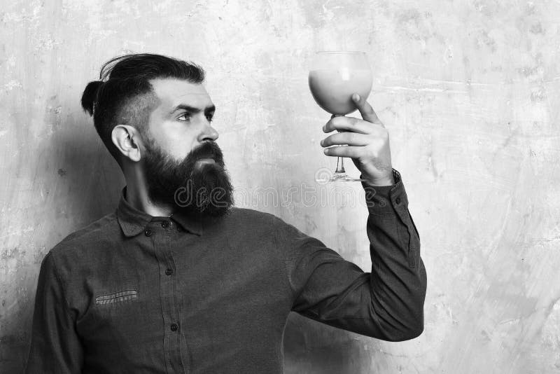 Brutal hipster holding tropical alcoholic fresh cocktail. Bearded man, long beard. Brutal caucasian serious hipster with moustache in blue denim shirt holding stock photography Brutal hipster holding tropical alcoholic fresh cocktail. Bearded man, long beard. Brutal caucasian serious hipster with moustache in blue denim shirt holding stock photography