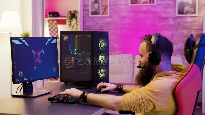 Bearded man playing online video games on his pc royalty free stock photo Bearded man playing online video games on his pc royalty free stock photo