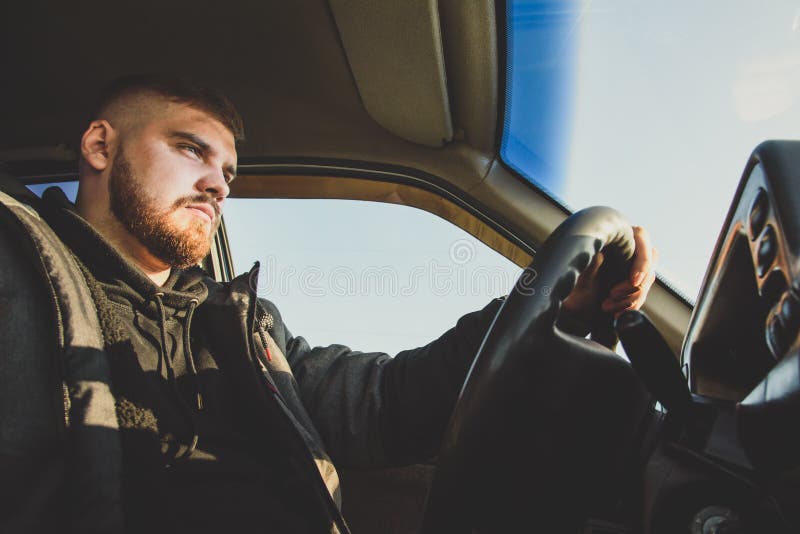 Bearded man sitting behind the wheel of the Russian