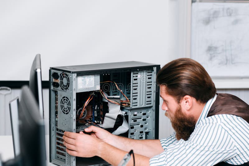 pleasant guy taking apart an old system unit, close up photo. guy overhaul  a computer in the office Stock Photo - Alamy