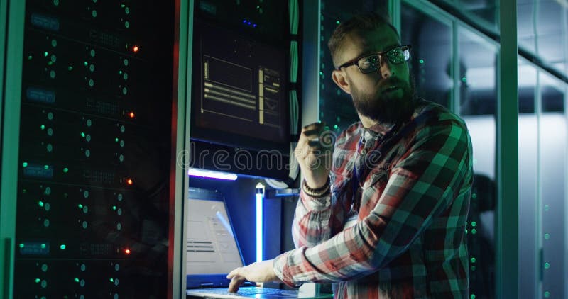 Bearded IT specialist setting servers in data center royalty free stock images
