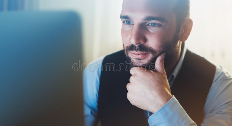 Bearded young businessman working on modern office. Consultant man thinking looking in monitor computer. Manager typing on keyboar royalty free stock photography
