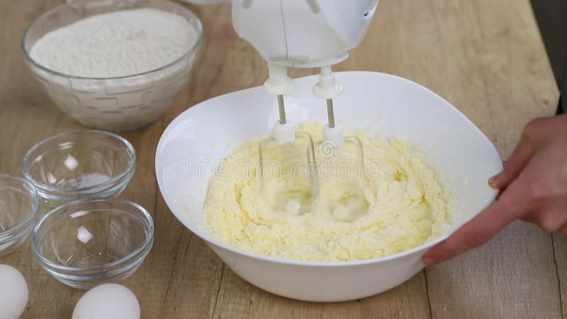 Beating butter with a mixer with whisk tips and adding a pinch of salt, the process of making shortbread dough stock video