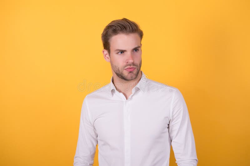 Beau avec la position blanche de port de chemise de poils sur le fond orange, mode d'affaires