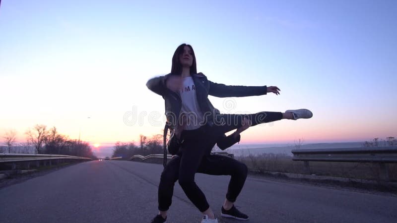 Beau ballet de danse de couples sur la route pendant l'aube, mouvement lent