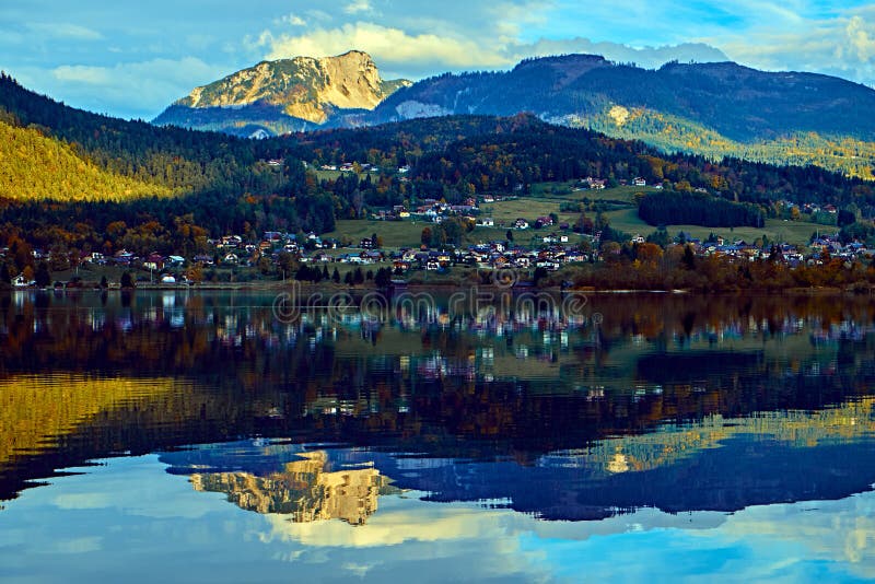 Beau coucher du soleil scénique au lac autrichien d'alpes Maisons rurales de vieux cru et péniches en bois dans les alpes au lac image libre de droits Beau coucher du soleil scénique au lac autrichien d'alpes Maisons rurales de vieux cru et péniches en bois dans les alpes au lac image libre de droits