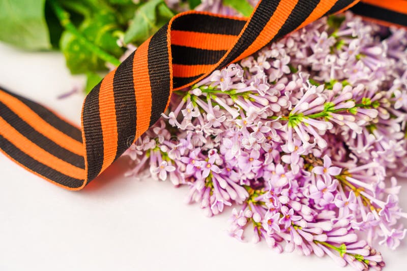 Beau fond floral avec st. george ribbon et lilac. bannière des fêtes de printemps avec une place pour le texte images stock