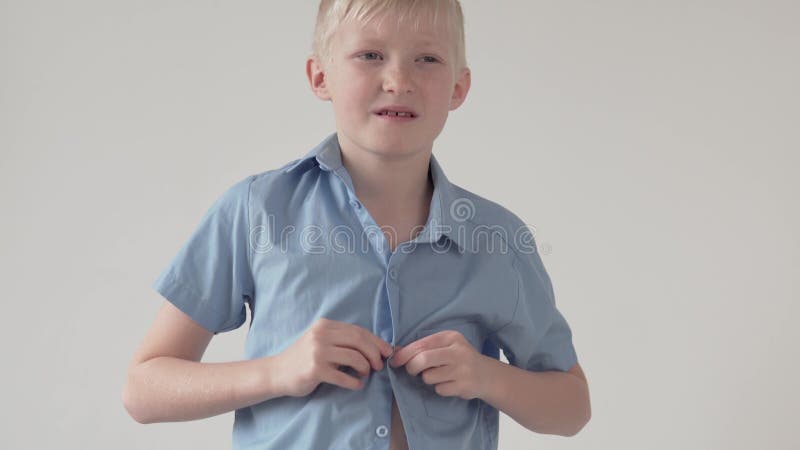 Beau garçon blond boutons sur la chemise de l'école