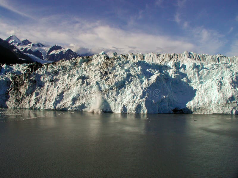 Beautiful Alaskan glacier with part breaking off in process known as caving. Beautiful Alaskan glacier with part breaking off in process known as caving.