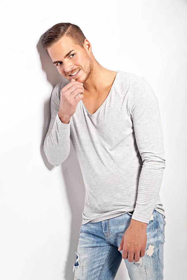 Beau jeune homme se penchant contre le mur blanc image libre de droits Beau jeune homme se penchant contre le mur blanc image libre de droits