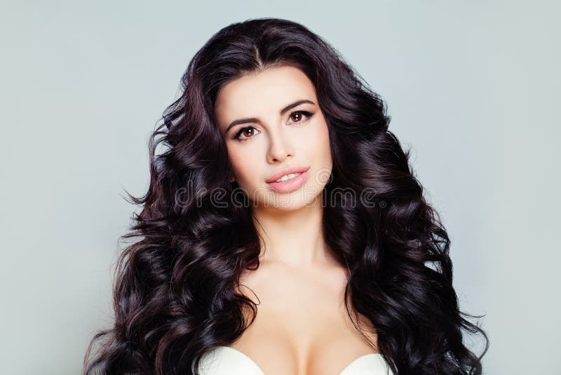 Beau modèle de femme avec de longs cheveux onduleux brillants et peau parfaite Joli modèle avec la coiffure bouclée photo libre de droits Beau modèle de femme avec de longs cheveux onduleux brillants et peau parfaite Joli modèle avec la coiffure bouclée photo libre de droits