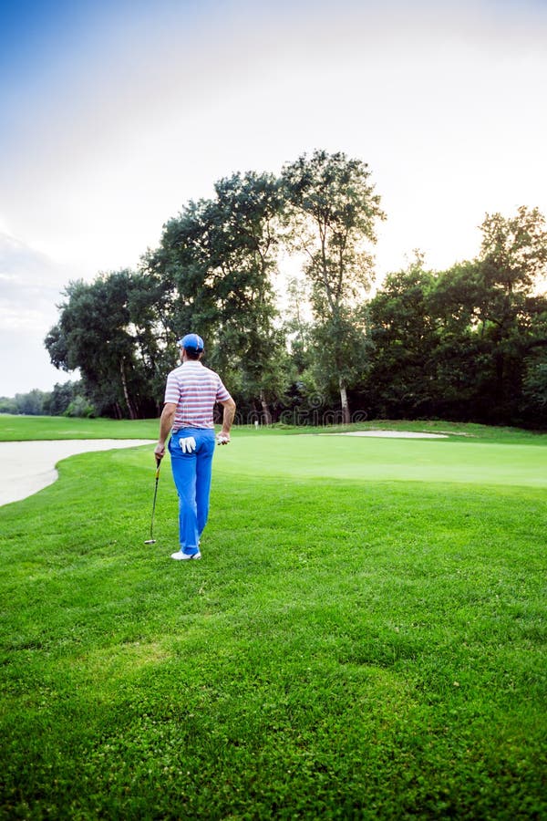 Beau paysage jouant au golf avec un golfeur tenant un club image libre de droits Beau paysage jouant au golf avec un golfeur tenant un club image libre de droits