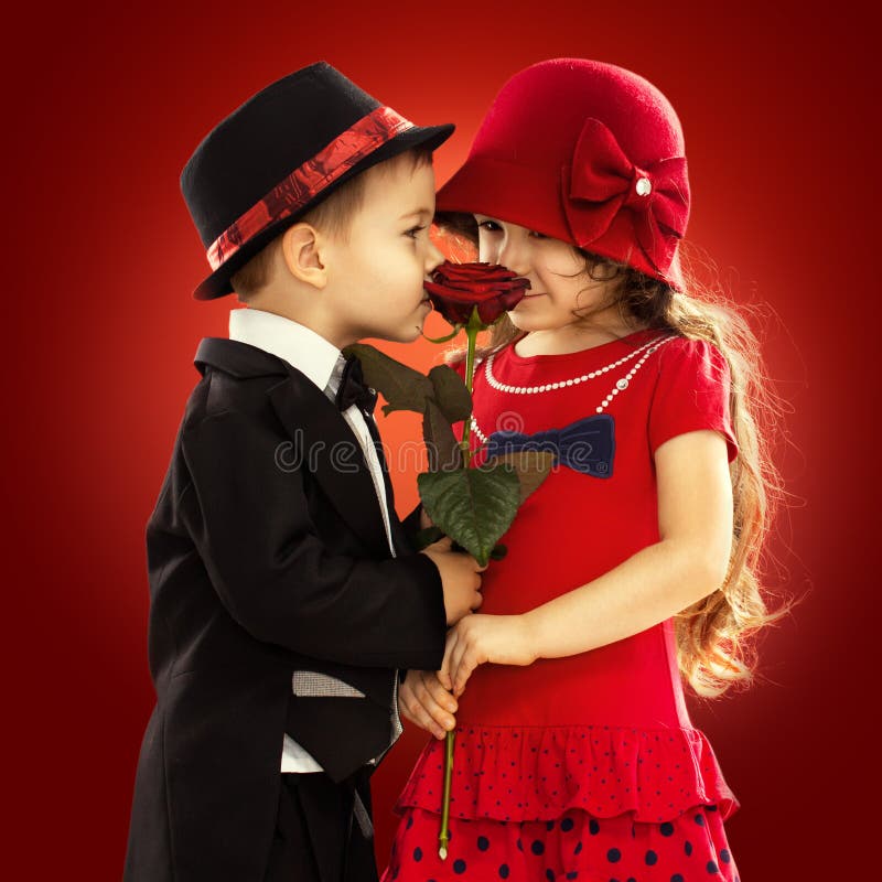 Beau petit garçon donnant une rose à la fille