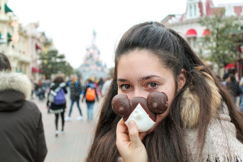 Beau sourire de fille avec une pâtisserie dans la main à la fête foraine photo libre de droits Beau sourire de fille avec une pâtisserie dans la main à la fête foraine photo libre de droits