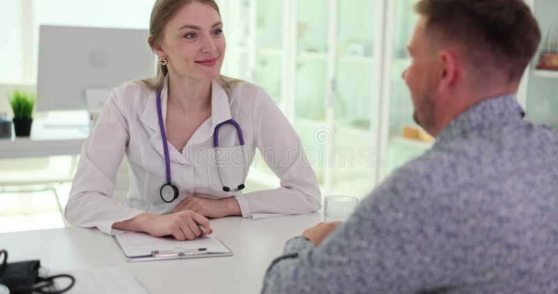 Beau sourire femme médecin communique avec un patient mâle clips vidéos