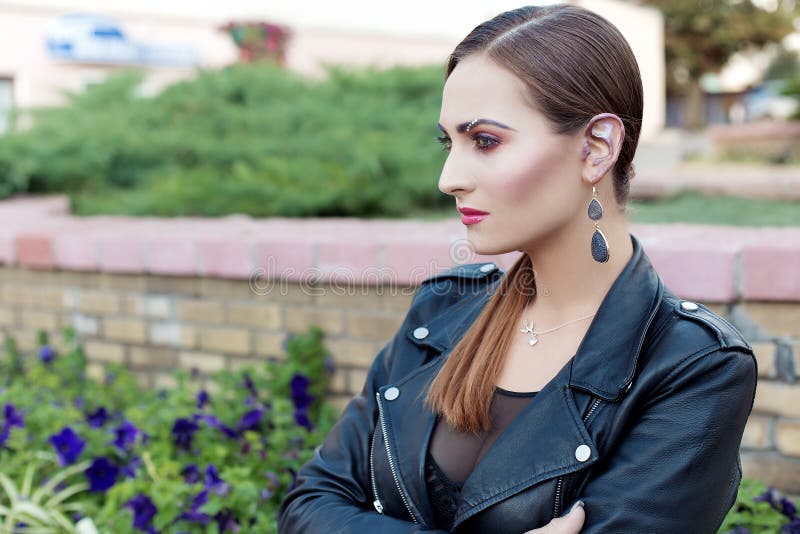 Beau tir d'une fille avec le maquillage à la mode lumineux dans la jupe en cuir noire dans le style de la roche fascinante photo stock