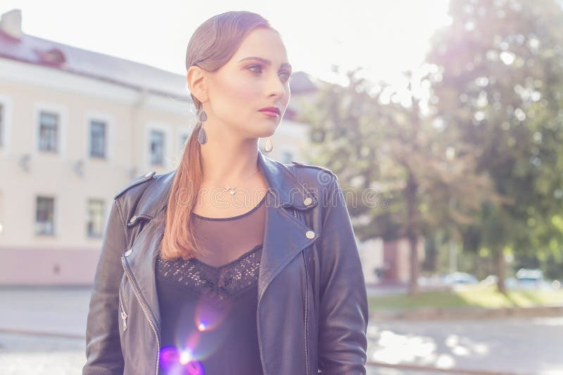 Beau tir d'une fille avec le maquillage à la mode lumineux dans la jupe en cuir noire à la lumière du soleil de luchas de style d image stock
