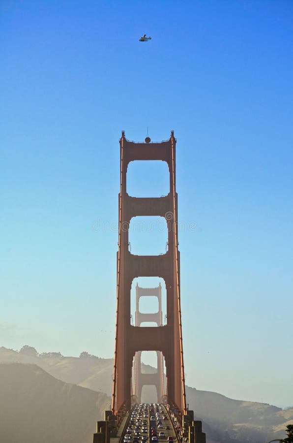 Beau tir vertical d'un pont occupé avec un bon nombre de trafic et d'un avion volant au-dessus photographie stock libre de droits Beau tir vertical d'un pont occupé avec un bon nombre de trafic et d'un avion volant au-dessus photographie stock libre de droits