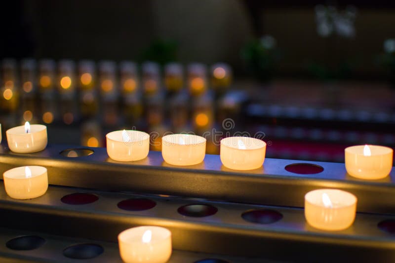Beaucoup de bougies brûlantes avec la profondeur du champ et du fond defocused photographie stock libre de droits Beaucoup de bougies brûlantes avec la profondeur du champ et du fond defocused photographie stock libre de droits