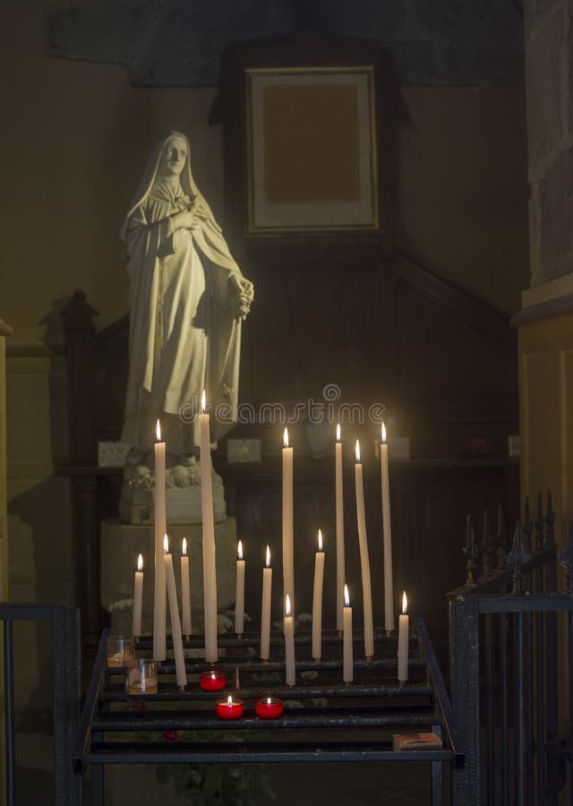 Beaucoup de bougies et statue de Vierge Marie dans une église image libre de droits Beaucoup de bougies et statue de Vierge Marie dans une église image libre de droits