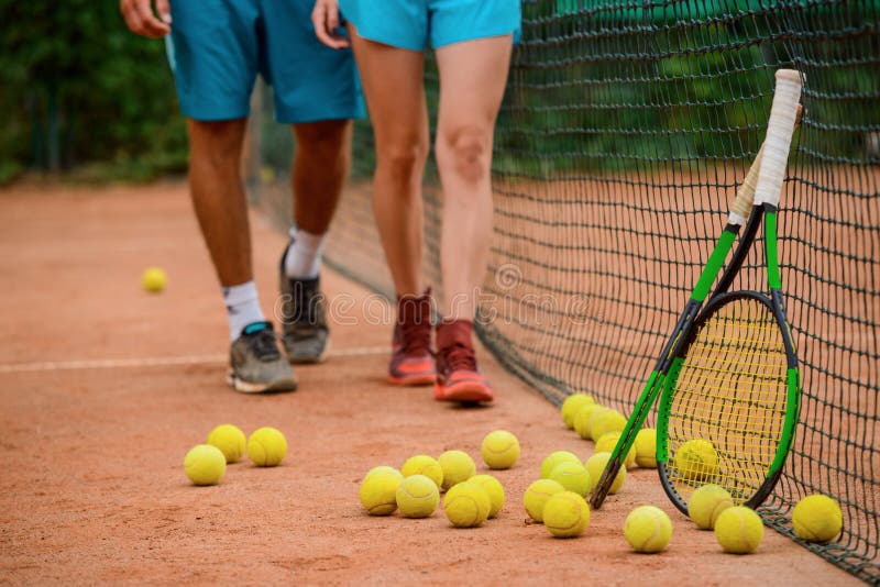 Beaucoup de boules posées sur un terrain extérieur et deux raquettes images stock Beaucoup de boules posées sur un terrain extérieur et deux raquettes images stock