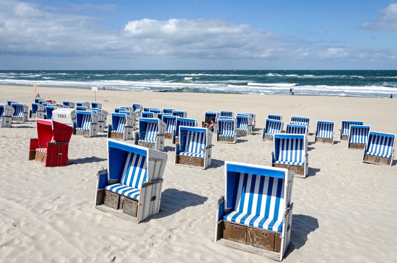 Beaucoup de chaises de plage sur la plage de sable en Allemagne du nord photographie stock libre de droits Beaucoup de chaises de plage sur la plage de sable en Allemagne du nord photographie stock libre de droits