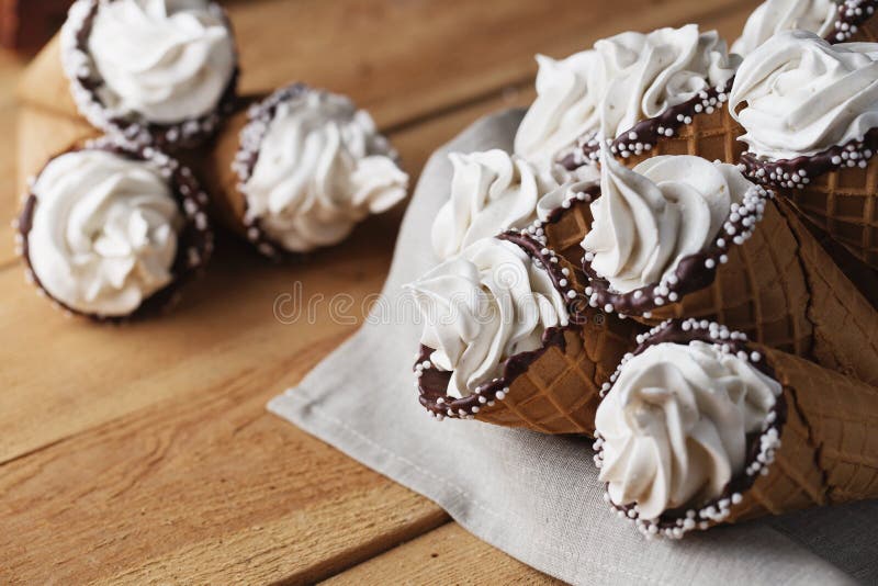 Beaucoup de cornets de crème glacée sur la table en bois Le mou crème ou crème anglaise surgelée dans les cônes Guimauves de gauf images stock Beaucoup de cornets de crème glacée sur la table en bois Le mou crème ou crème anglaise surgelée dans les cônes Guimauves de gauf images stock