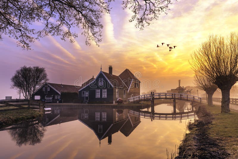 Krásný a typický holandský dřevěné domy architektura zrcadlí na klidné kanálu Zaanse Schans se nachází v Severní části Amsterdamu, Nizozemsko.
