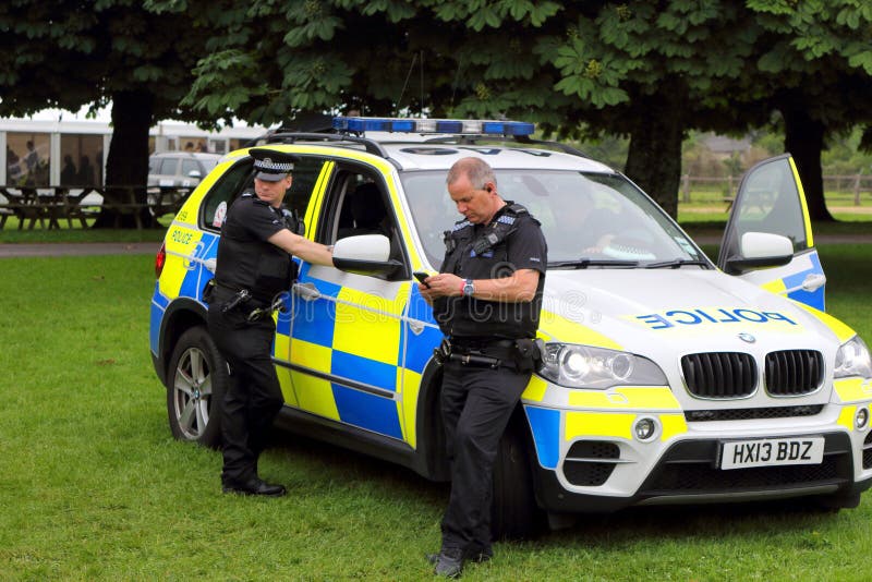 Beaulieu, Hampshire, UK - May 29 2017: Two British policemen taking a break with their BMW patrol car