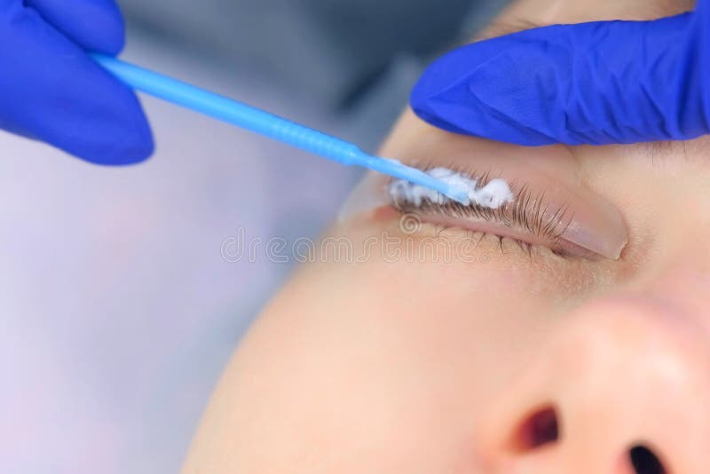 Cosmetologist apply solution for lamination on lashes, lift eyelashes procedure.